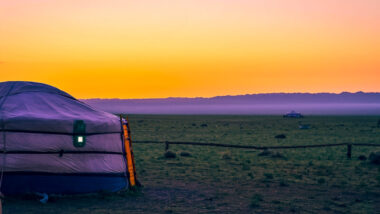 Sunset at a ger camp near the sand dunes. Learn about what it is like to stay at a Mongolian Ger Camp. Learn about the what a ger is (the Mongolian yurt) and what to expect when staying at a Ger Camp! #mongolia #ger #gercamp #travelmongolia