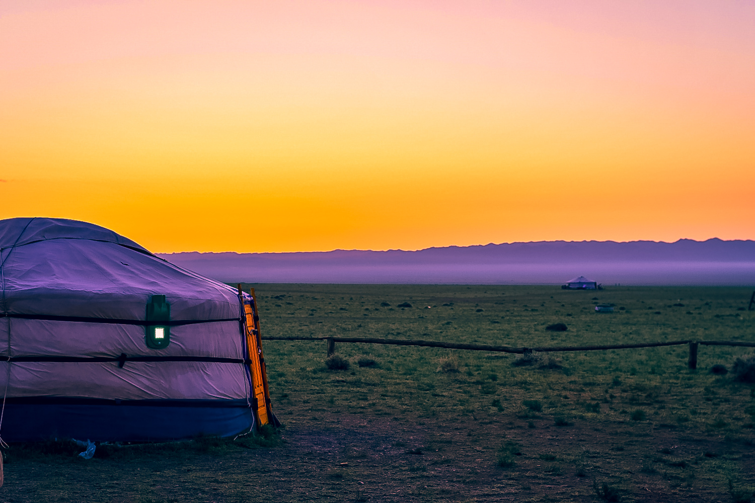 Sunset at a ger camp near the sand dunes. Learn about what it is like to stay at a Mongolian Ger Camp. Learn about the what a ger is (the Mongolian yurt) and what to expect when staying at a Ger Camp! #mongolia #ger #gercamp #travelmongolia