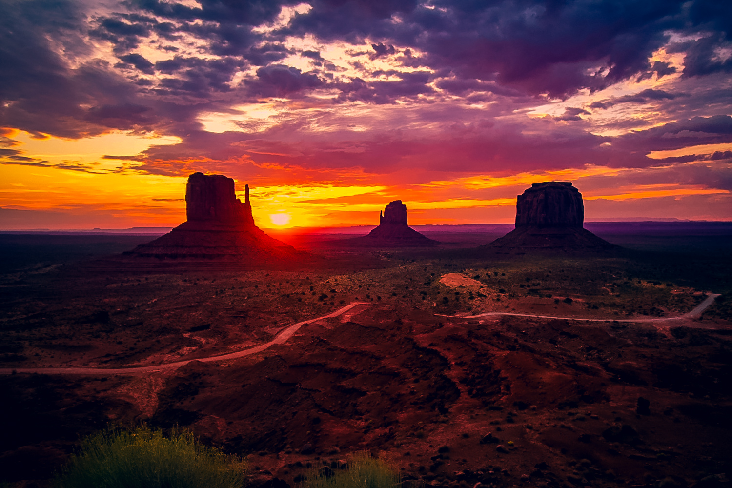 Scenic drive at sunrise at Monument Valley. Monument Valley has two famous spots: sunrise of Mitten Buttes and Merrick Buttes, and then sunset at the famous Forrest Gump movie scene location. Learn about what to expect visiting Monument Valley, and how to capture the best photos while visiting! #monumentvalley #buttes #desert
