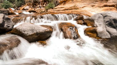 Small waterfalls at slide rock state park. Looking for things to do in Sedona, Arizona? Then check out one of the world's natural water slides. Slide Rock State Park offers an escape from the Arizona heat with a chance to dip in the chilly water - or slide down the smooth rocks. #arizona #sliderock #sedona