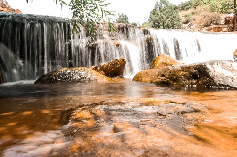 Small waterfalls at slide rock state park. Looking for things to do in Sedona, Arizona? Then check out one of the world's natural water slides. Slide Rock State Park offers an escape from the Arizona heat with a chance to dip in the chilly water - or slide down the smooth rocks. #arizona #sliderock #sedona 