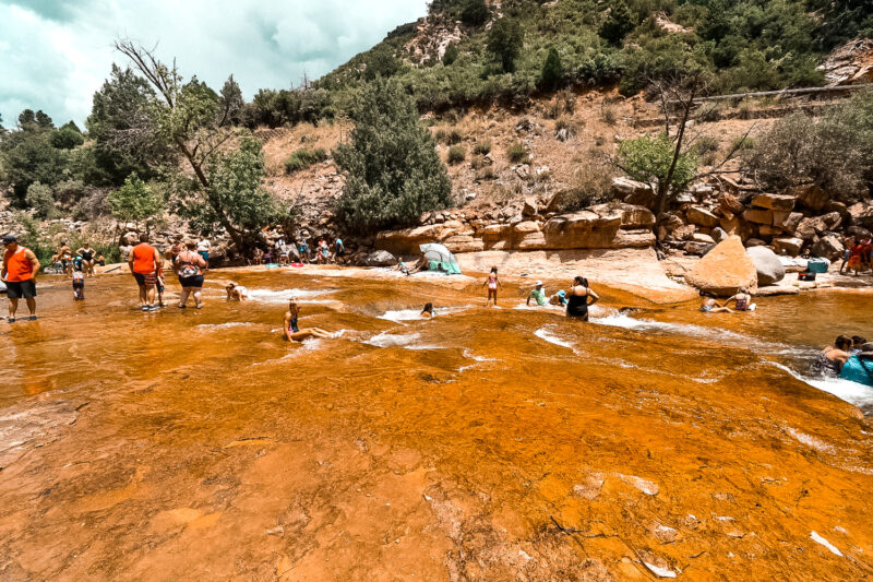Crowds at slide rock state park. Looking for things to do in Sedona, Arizona? Then check out one of the world's natural water slides. Slide Rock State Park offers an escape from the Arizona heat with a chance to dip in the chilly water - or slide down the smooth rocks. #arizona #sliderock #sedona 