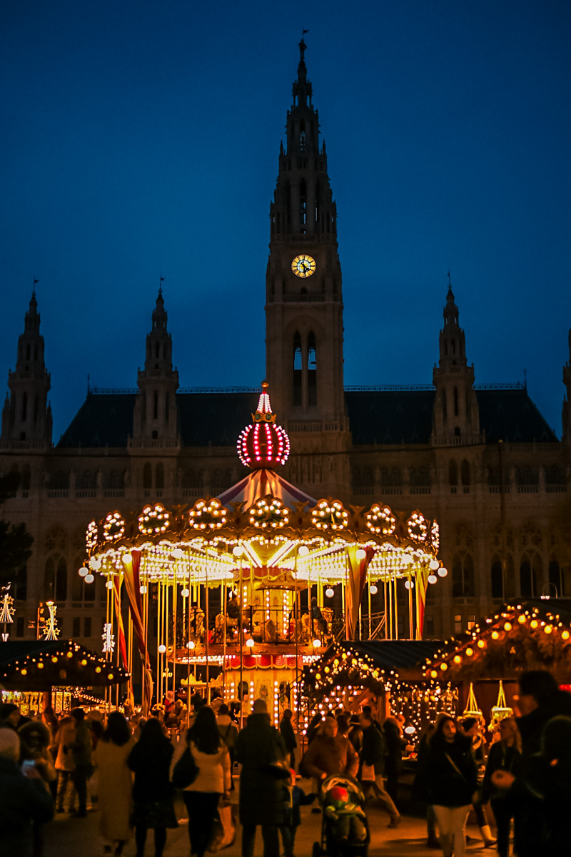 Stunning view of Vienna’s Rathausplatz Christmas Market with glowing lights, festive stalls, and the iconic City Hall in the background.
