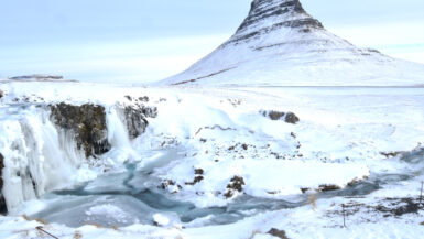 Kirkjufellsfoss, nestled beneath the iconic Kirkjufell Mountain, transforms into a serene winter masterpiece. The cascading falls, blanketed in snow, create a picturesque scene that embodies the enchanting beauty of Iceland in winter. A must-visit destination for those seeking the ethereal charm of Kirkjufellsfoss in the snow.