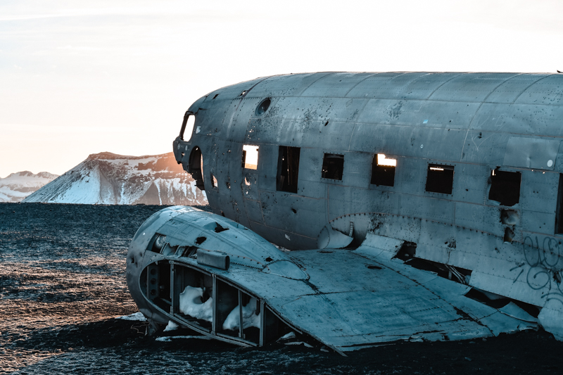 DC Plane Wreck: Explore the surreal scene of a US Navy plane wreckage on Sólheimasandur Beach. A unique photo opportunity against the snowy backdrop during your Iceland winter road trip.