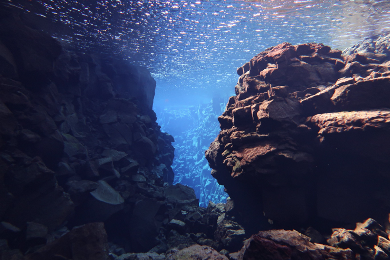Silfra Diving: Immerse yourself in the crystal-clear waters of Silfra Fissure during your week-long road trip through Iceland in winter. Dive or snorkel between tectonic plates, capturing mesmerizing underwater landscapes in Thingvellir National Park.