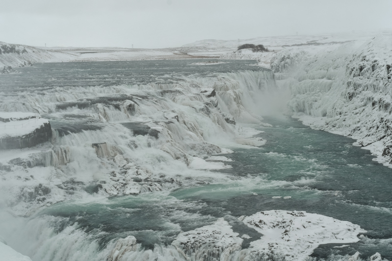 Gullfoss, Iceland's majestic 'Golden Waterfall,' showcases the raw power of nature as glacial waters cascade dramatically into a deep canyon, surrounded by the icy embrace of winter. A captivating sight along the Golden Circle, Gullfoss captivates with its frozen beauty, creating an unforgettable Icelandic winter wonder